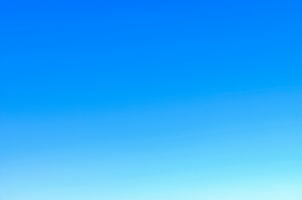 A serene view of a vibrant clear blue sky with a subtle gradient, perfect for backgrounds.